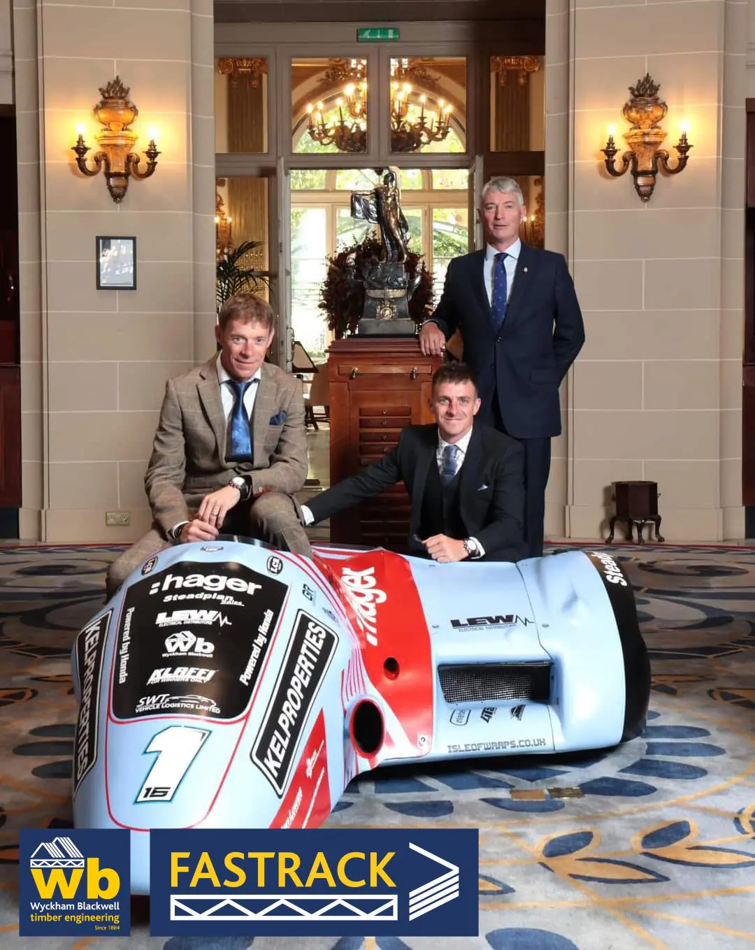 Three men stood by a race car