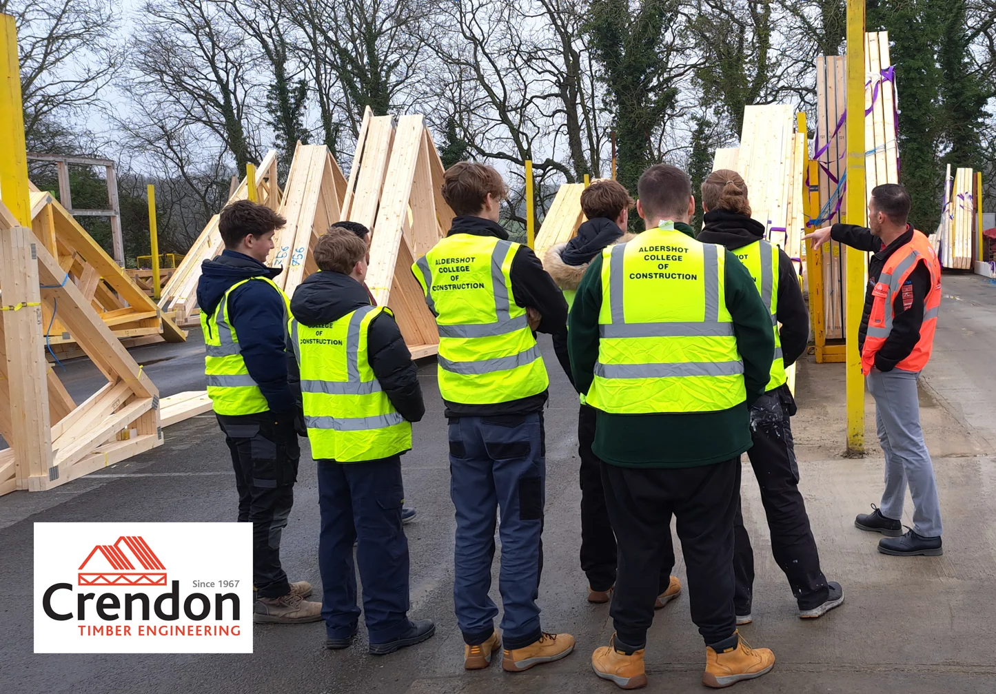 Group of men in hi-vis jackets in wood yard