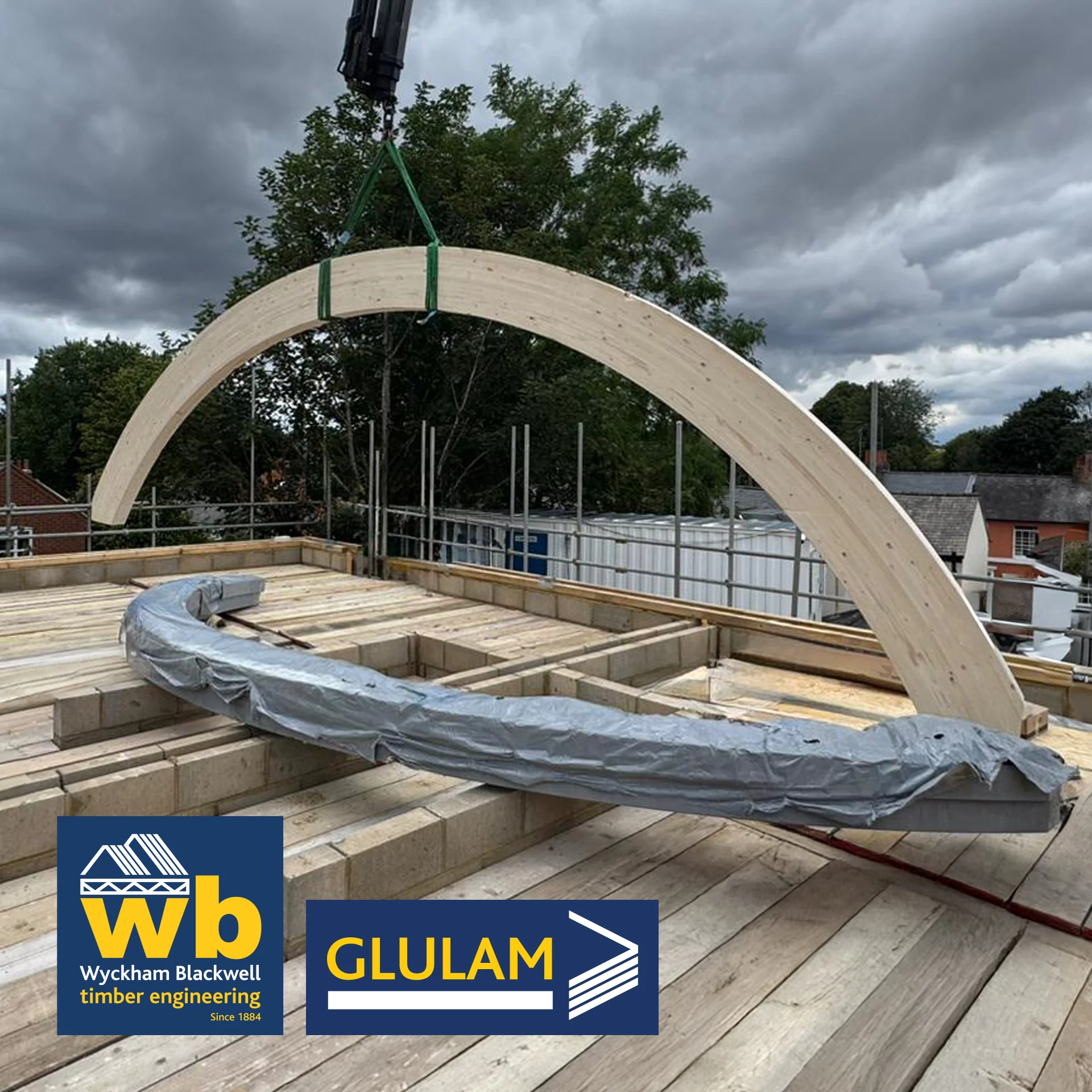 Curved glulam beam being lifted onto building site