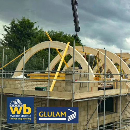 Multiple curved glulan beams on building under construction