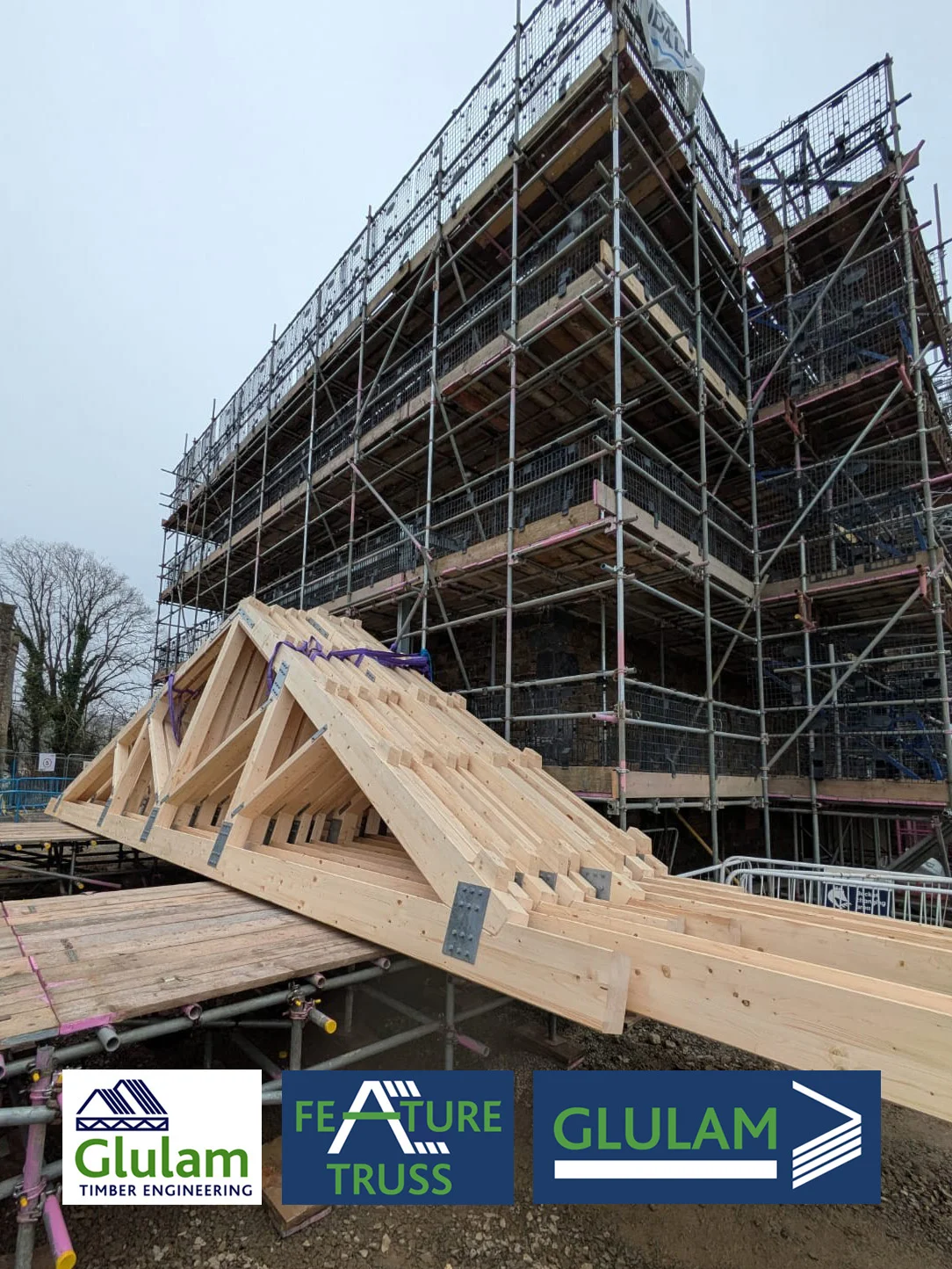 Side view of feature truss lent against scaffolded building