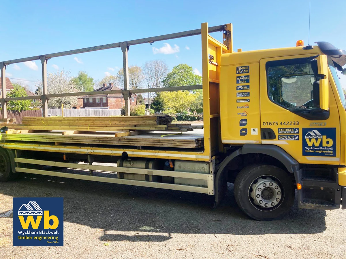 Yellow Wyckham Blackwell flat bed lorry with timber on