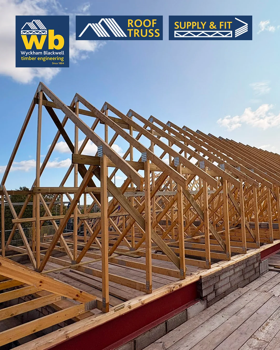 Rows of timber Roof Trusses on a building frame under a blue sky, with Wyckham Blackwell logos above.