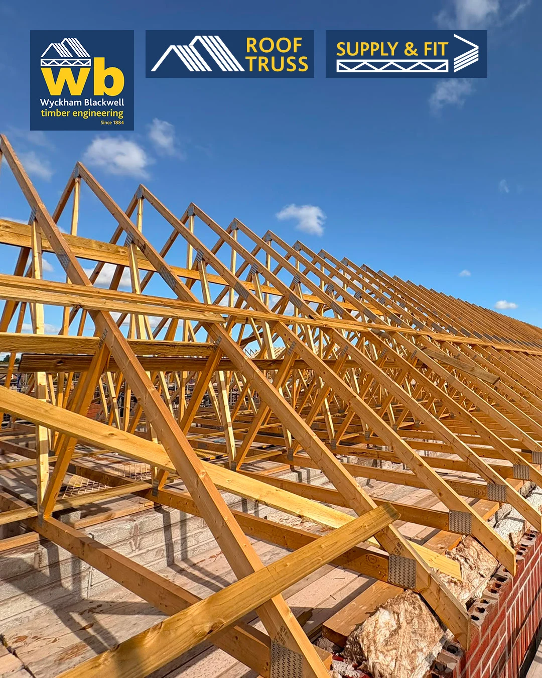 Rows of timber Roof Trusses on a building frame under a blue sky, with Wyckham Blackwell logos above.