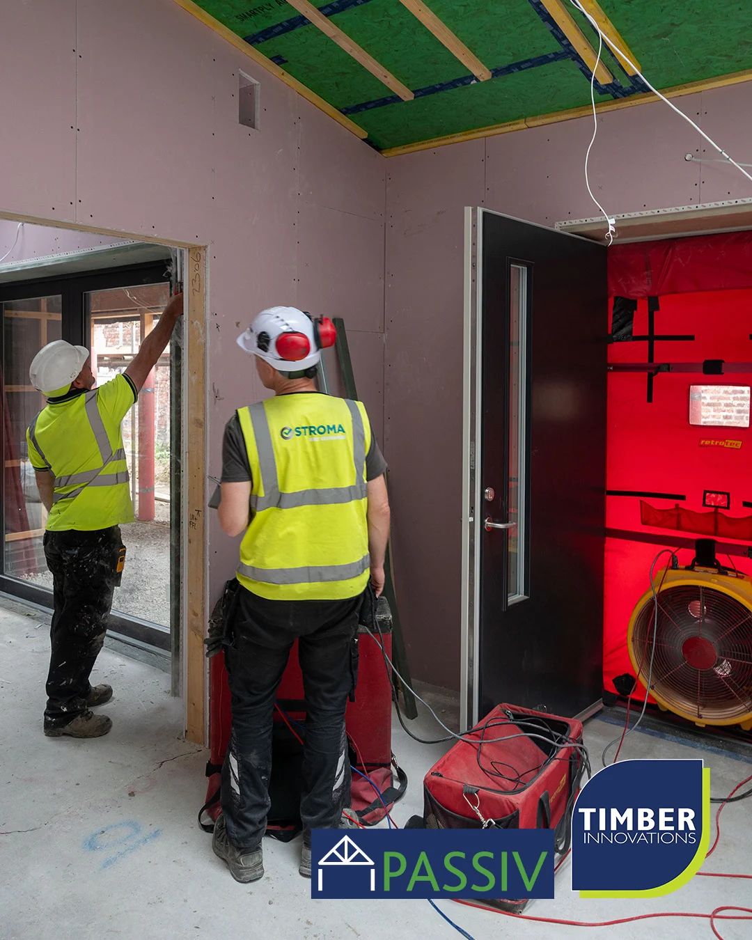Men in hi vis and hard hat performing airtightness testing